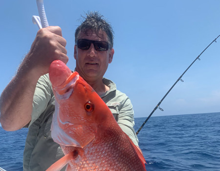  Another fisherman posing with their catch aboard the Salty Hooks