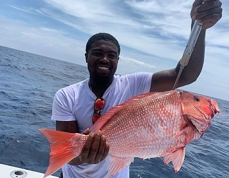  Man holding up fish on boat