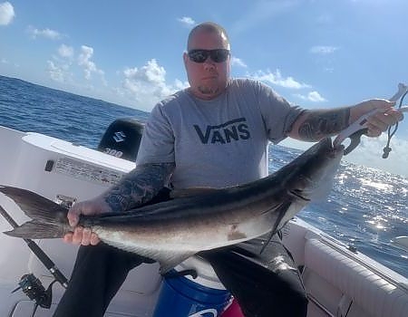 Posing on deck of boat with fish