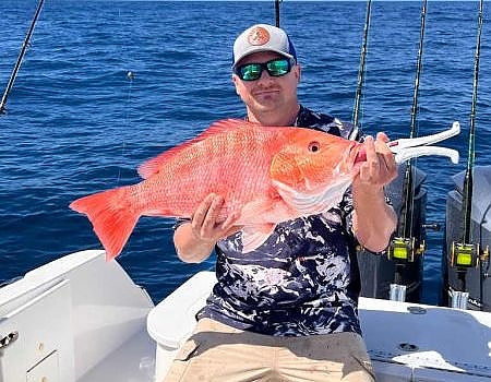 Man holds up fish caught with two hands