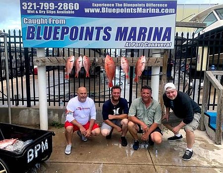 Group poses in front of the Bluepoints Marina sign