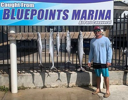  Man poses in front of the Bluepoints Marina sign