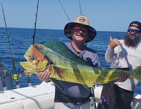 Man aboard boat holds up a huge fish